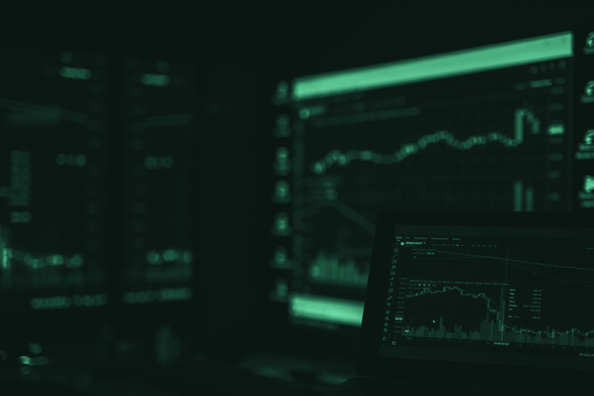 Dealing-desk screens glowing with market charts in a dark trading room